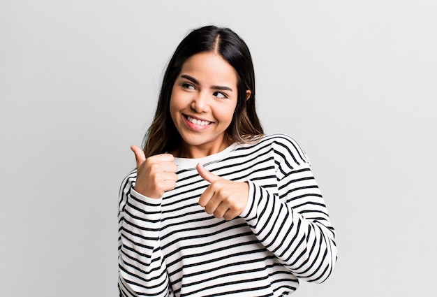Souriant joyeusement et désagréablement pointant vers l'espace de copie sur le côté se sentant heureux et satisfait