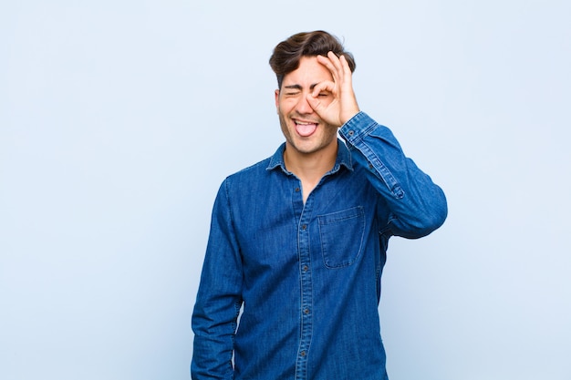 souriant joyeusement avec une drôle de tête, plaisantant et regardant à travers un judas