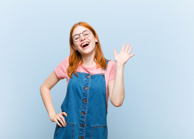 souriant joyeusement et joyeusement, agitant la main, vous accueillant et vous saluant, ou vous disant au revoir