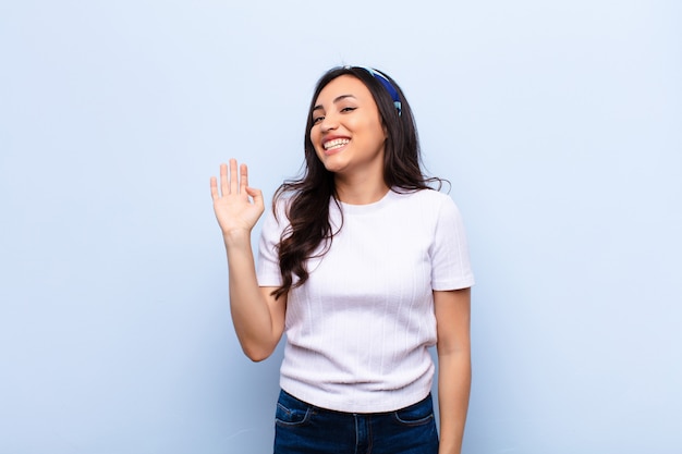 souriant joyeusement et joyeusement, agitant la main, vous accueillant et vous saluant, ou vous disant au revoir