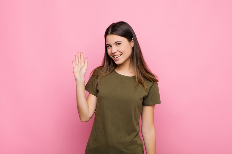Photo souriant joyeusement et joyeusement, agitant la main, vous accueillant et vous saluant, ou vous disant au revoir