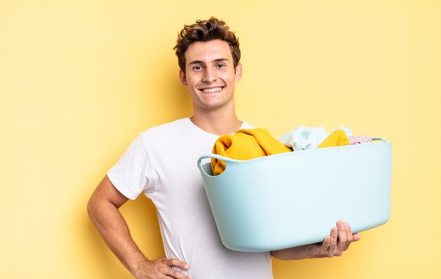 Souriant joyeusement avec une main sur la hanche et une attitude confiante, positive, fière et amicale. concept de lavage de vêtements