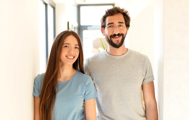 souriant joyeusement avec une main sur la hanche et une attitude confiante, positive, fière et amicale