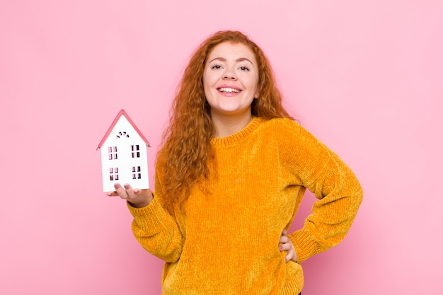 souriant joyeusement avec une main sur la hanche et une attitude confiante, positive, fière et amicale