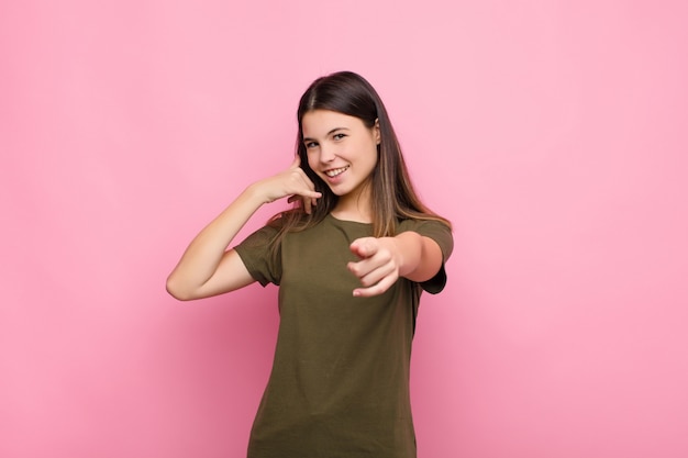 souriant joyeusement et pointant vers la caméra tout en vous appelant par la suite, en parlant au téléphone