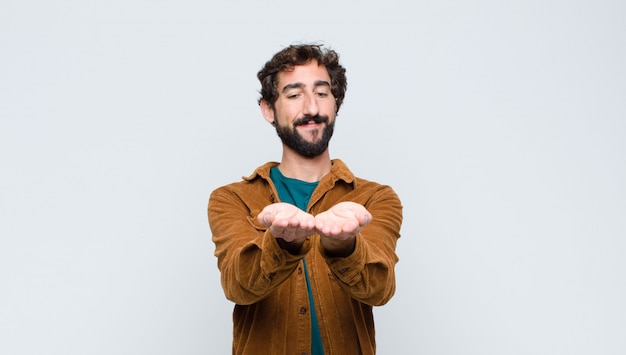 souriant joyeusement avec un regard amical, confiant et positif, offrant et montrant un objet ou un concept
