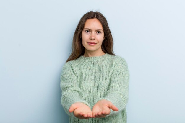 souriant joyeusement avec un regard positif confiant amical offrant et montrant un objet ou un concept