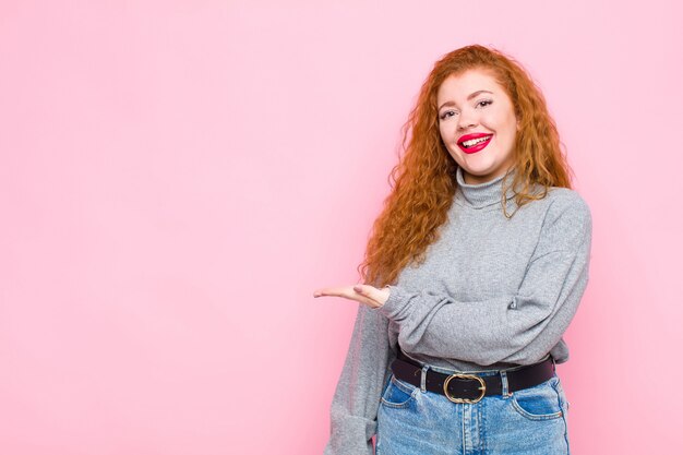 souriant joyeusement, se sentant heureux et montrant un concept dans l'espace de copie avec la paume de la main