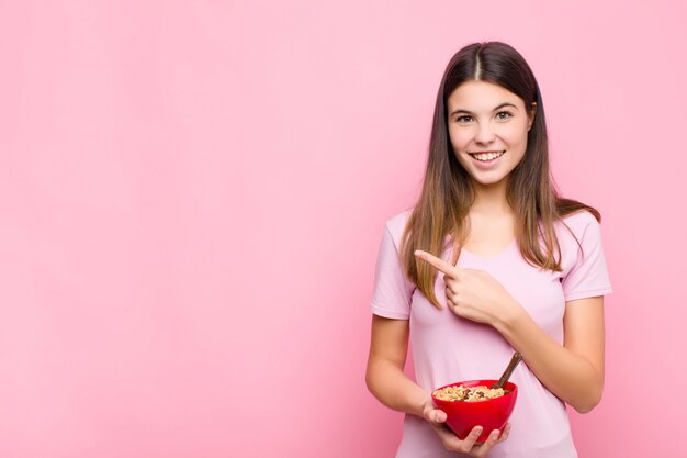 souriant joyeusement, se sentant heureux et pointant vers le côté et vers le haut