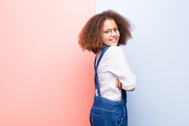 Photo souriant joyeusement, se sentant heureux, satisfait et détendu, les bras croisés et regardant sur le côté