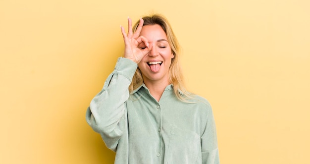 Photo souriant joyeusement avec un visage drôle en plaisantant et en regardant à travers un judas espionnant des secrets