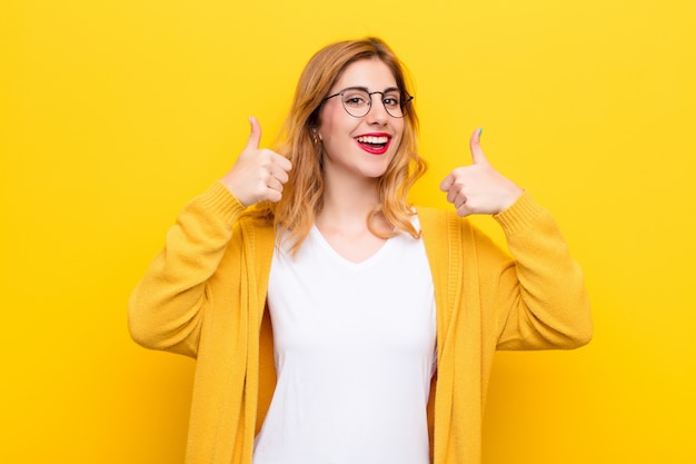 souriant largement, heureux, positif, confiant et réussi, les deux pouces levés