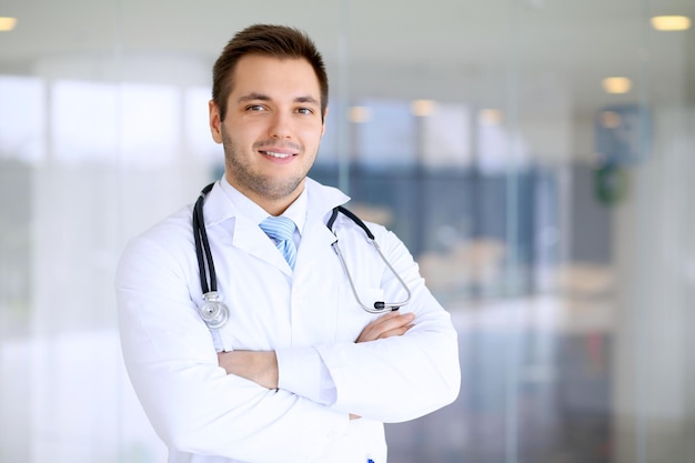 Photo souriant médecin homme debout tout droit à l'hôpital