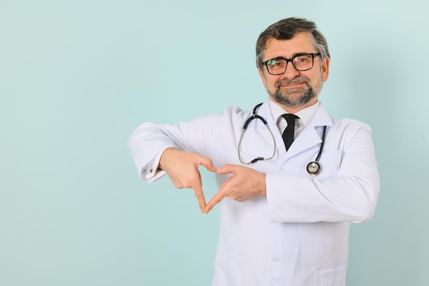 Souriant médecin senior avec un stéthoscope Sur un fond bleu Le concept de la victoire de l'humanité sur la maladie