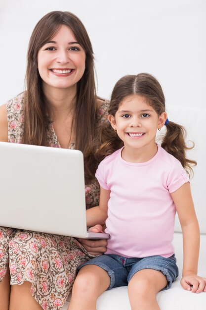 Souriant mère et fille avec ordinateur portable