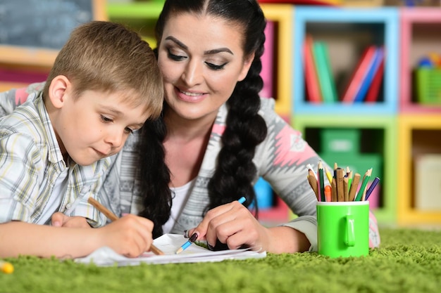 Souriant mère et fils dessinant avec des crayons