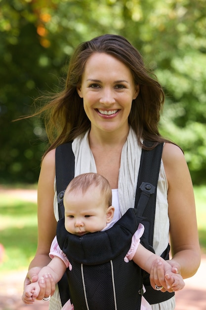 Souriant mère marchant en plein air avec bébé