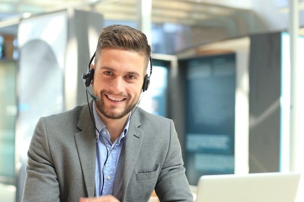 Souriant opérateur de centre d'appels beau jeune homme sympathique.