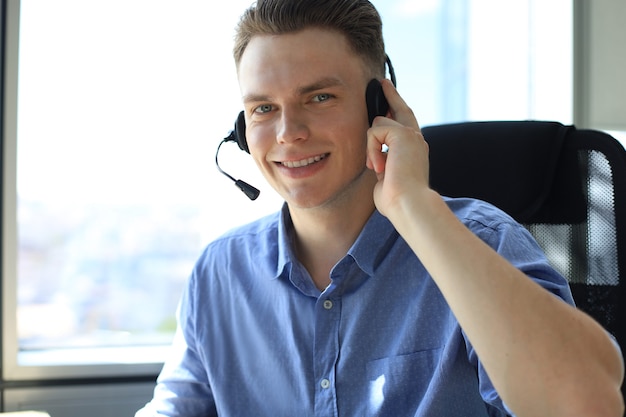 Souriant opérateur de centre d'appels beau jeune homme sympathique.