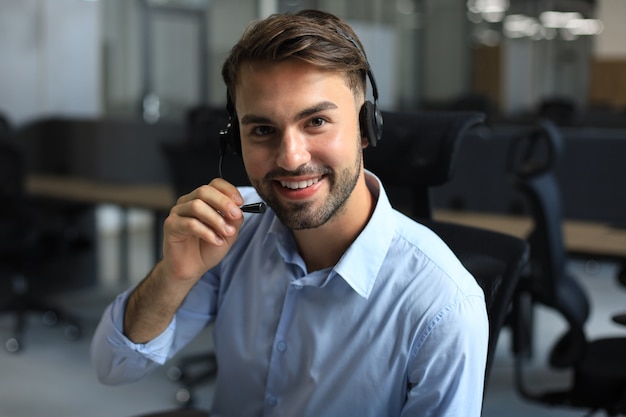 Souriant opérateur de centre d'appels beau jeune homme sympathique.