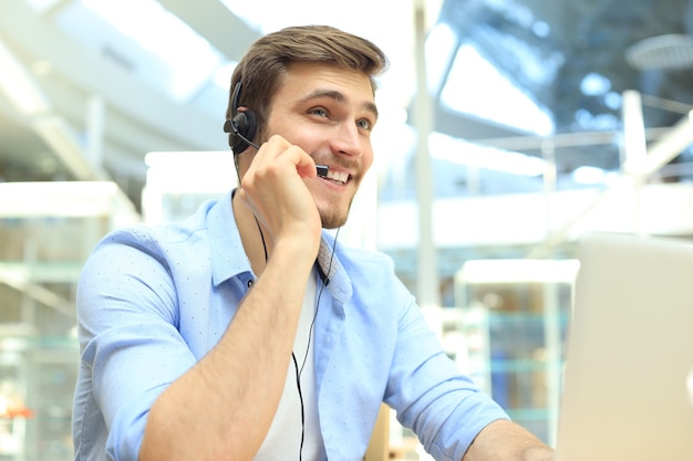 Souriant opérateur de centre d'appels beau jeune homme sympathique.