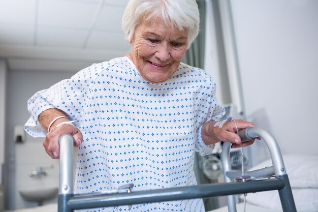 Souriant patient senior tenant un cadre de marche