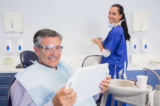 Photo souriant patient tenant un miroir