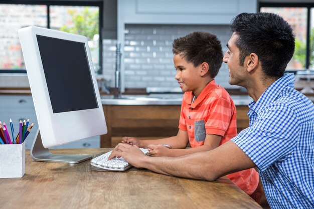 Souriant père à l&#39;aide d&#39;ordinateur avec son fils