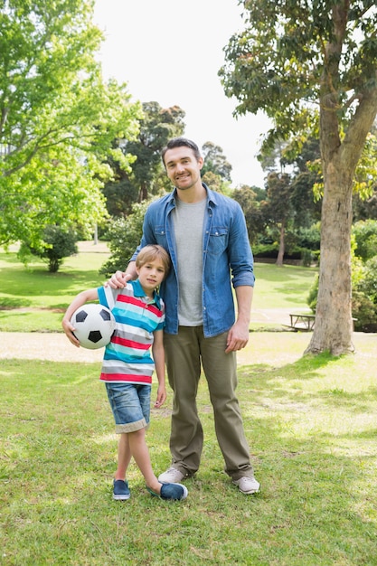 Souriant père et fils avec ballon au parc