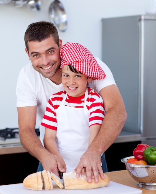 Souriant père et fils coupe le pain