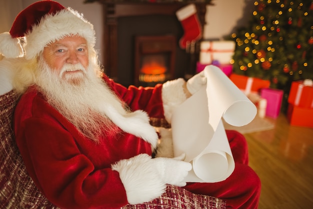 Souriant père noël lisant sa liste