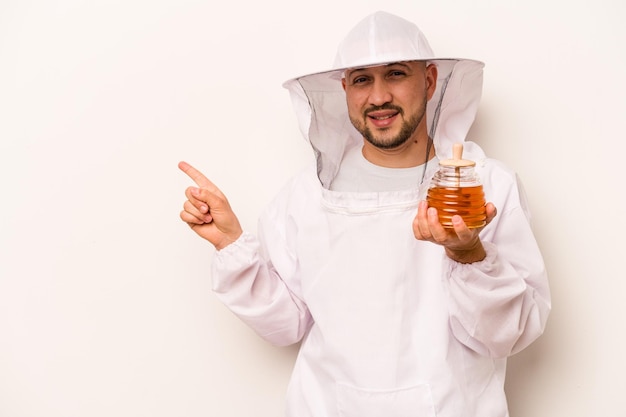 Souriant et pointant de côté montrant quelque chose dans un espace vide