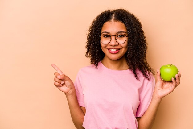 Souriant et pointant de côté montrant quelque chose dans un espace vide