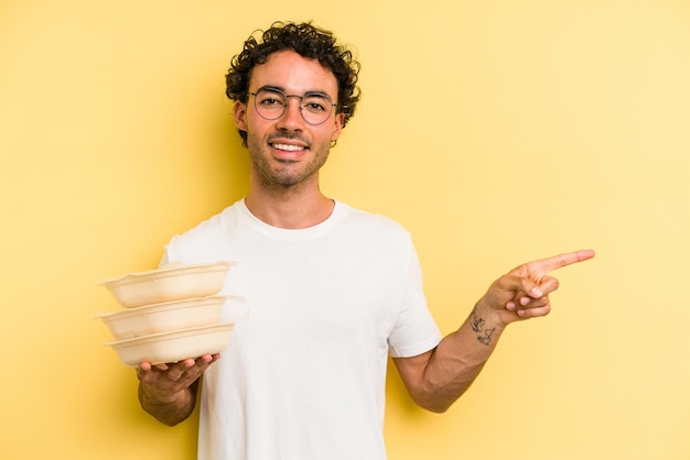 Souriant et pointant de côté montrant quelque chose dans un espace vide