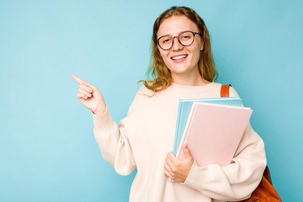 Souriant et pointant de côté montrant quelque chose dans un espace vide