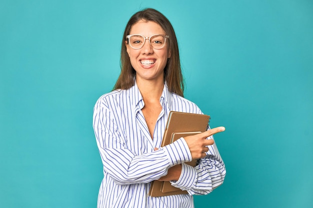 Souriant et pointant de côté montrant quelque chose dans un espace vide