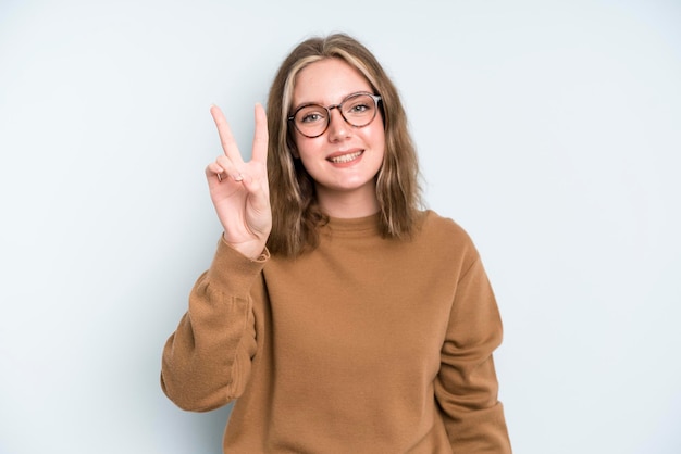 souriant et à la recherche d'une victoire ou d'une paix gesticulant sans soucis et positive d'une main