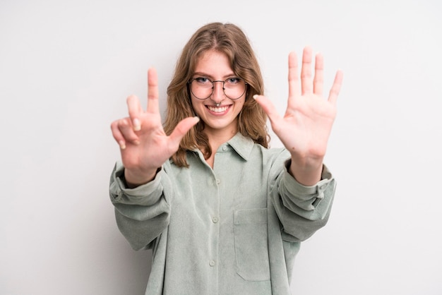 Souriant et regardant amicalement montrant le numéro sept ou sept avec la main en avant comptant à rebours