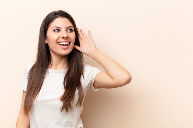 souriant, regardant curieusement sur le côté, essayant d'écouter des potins ou d'entendre un secret