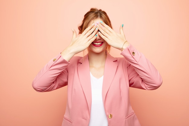 souriant et se sentant heureux, couvrant les yeux des deux mains et attendant une surprise incroyable