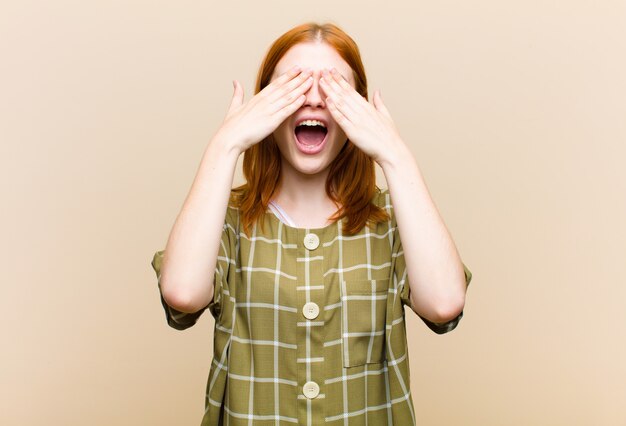 Photo souriant et se sentant heureux, couvrant les yeux des deux mains et attendant une surprise incroyable