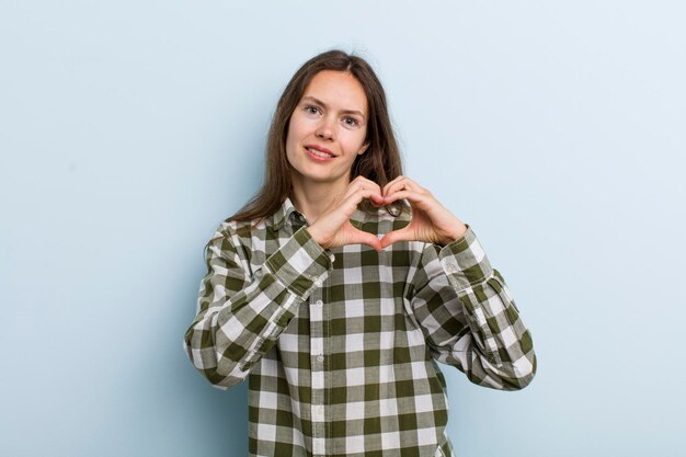 souriant et se sentir heureux mignon romantique et amoureux en forme de coeur avec les deux mains