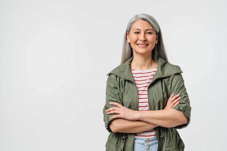 Photo souriant avec un sourire denté femme d'âge moyen mature en vêtements décontractés avec des cheveux gris regardant la caméra bras croisés isolés sur un fond blanc