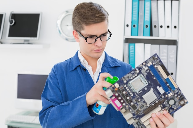 Souriant technicien travaillant sur un ordinateur cassé