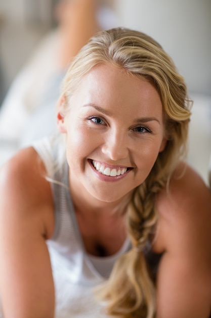 Souriante belle femme allongée sur le lit dans la chambre