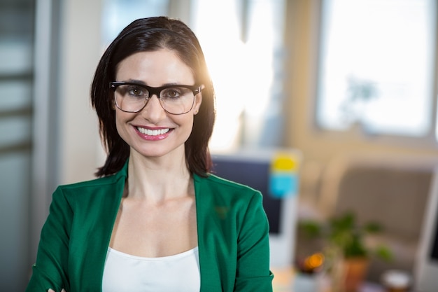 Souriante brune debout et regardant la caméra