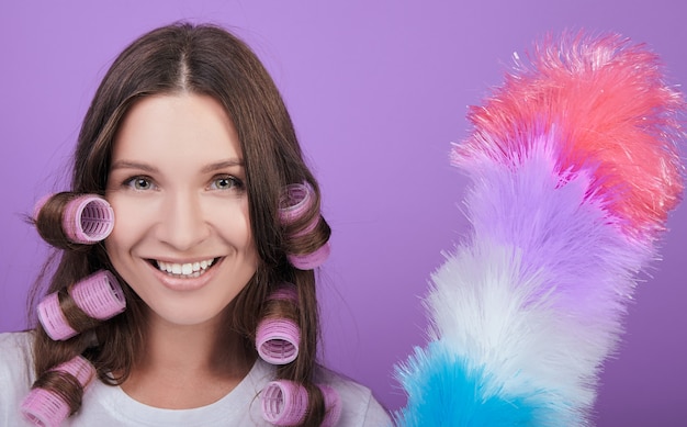 Souriante femme brune aux yeux verts en bigoudis.