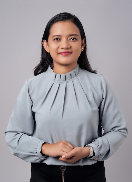 Photo souriante, heureuse, jeune femme d'affaires asiatique d'une trentaine d'années, confiante devant la caméra, isolée sur un fond gris.