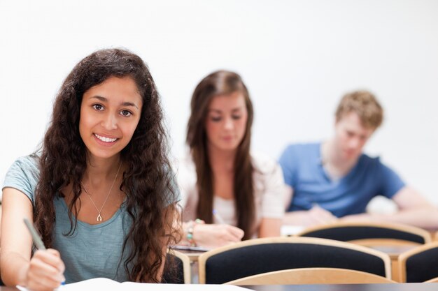 Photo souriante jeune étudiants assis