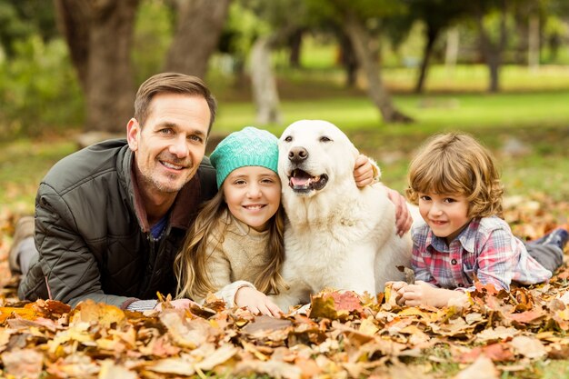 Photo souriante jeune famille avec un chien